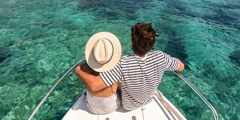 Paar auf dem Deck einer Yacht vor der Küste Mallorcas