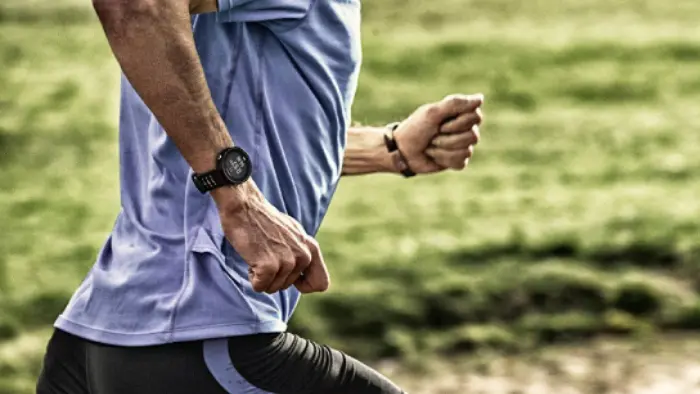 Mann beim Morgenlauf mit Smart Watch am Handgelenk