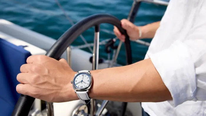 Elegante Uhr zur Anzugmanschette am Steuer einer Yacht